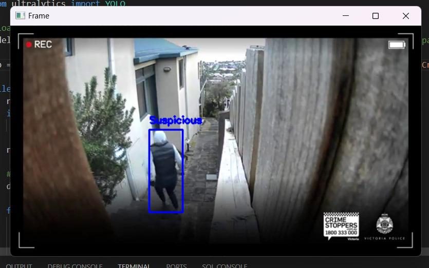 A live CCTV frame from the system: a person in an alley outlined by a blue detection box labeled Suspicious.